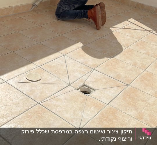 אדם מורח חומר איטום על רצפת אריחים